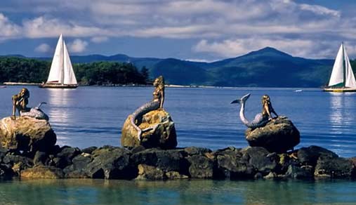 Three Daydream-Island-mermaid-sculptures on the waters edge by David Joffe